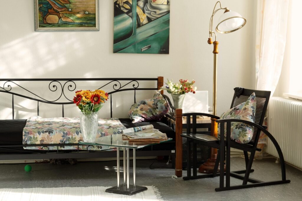 Charming living room featuring artistic decor, floral pillows, and cozy seating in natural light.